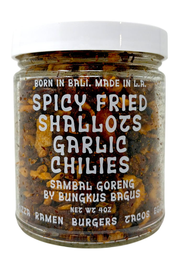 Jar of spicy fried shallots, garlic, and chilies with a white lid on a white background.